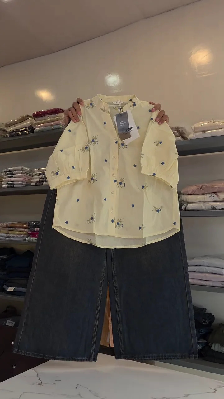 ✨ Add Fresh Floral Charm To Your Everyday Wardrobe With This Beautiful Pastel Yellow Button-Down Shirt Featuring Delicate Blue Flower Prints, A Stylish Stand Collar, Relaxed Three-Quarter Sleeves, Graceful Curved Hemline & Coordinated Dark Wide-Leg Denim Jeans 💛